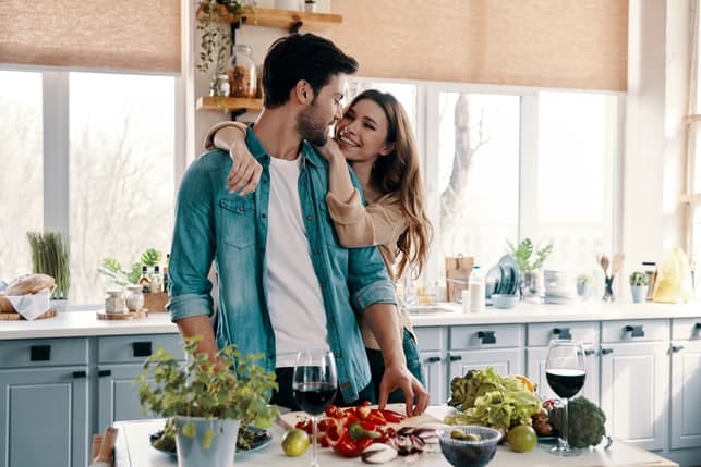 a couple is hugging and spending time in the kitchen together
