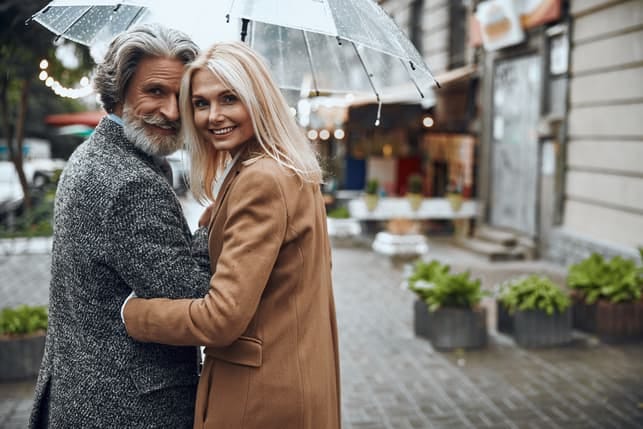 a romantic couple is having a walk under an umbrella