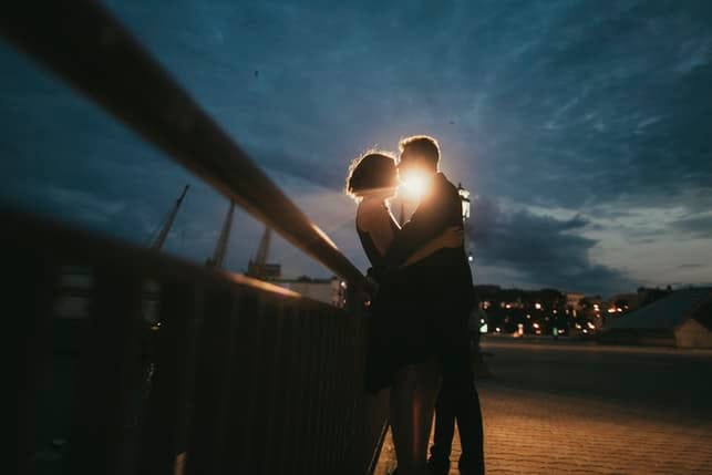 a romantic couple kissing in the evening