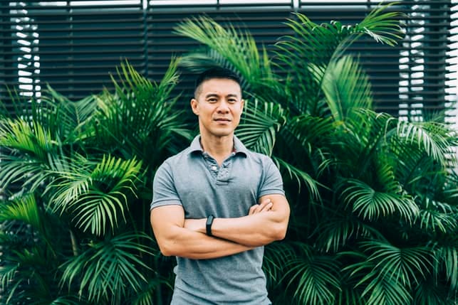 a serious asian man posing outdoors