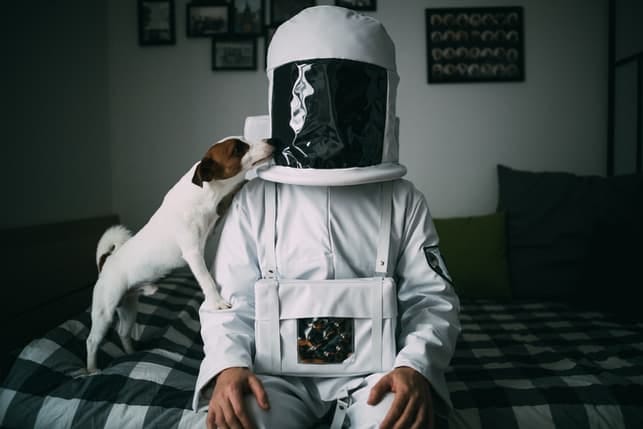 a dog and a man wearing a spacesuit