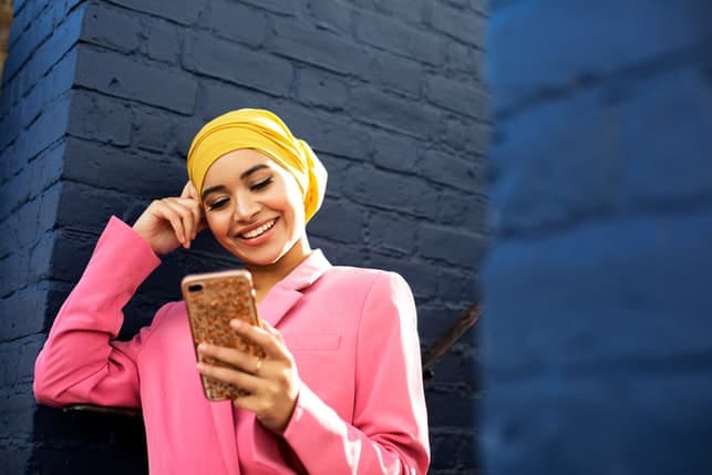 a modern woman in a muslim clothing chatting on her phone