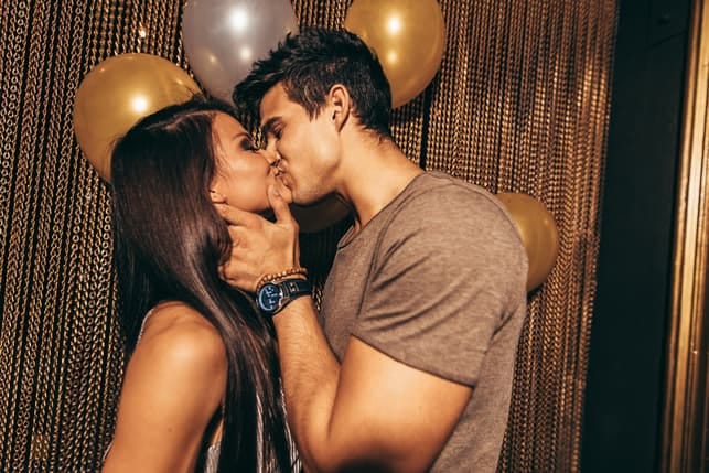 a guy is kissing his girlfriend on a party