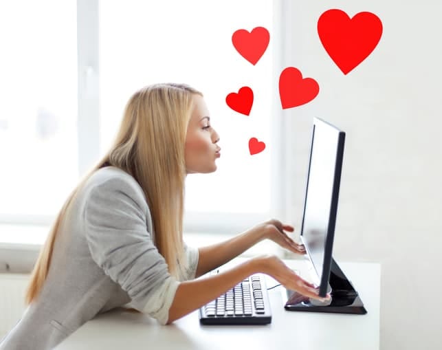 a woman is enjoying her online dating and sending hearts to her partner